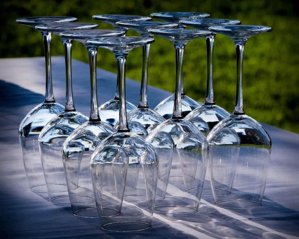 An intriguing sight of a table covered with numerous upside-down wine glasses at an event.